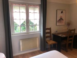 布雷斯特滨海之家酒店的一间卧室配有一张床、一张书桌和一个窗户。