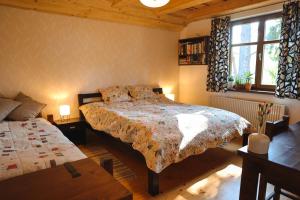 斯米扎尼Chata u Gregora v Slovenskom raji的卧室配有床、桌子和窗户。