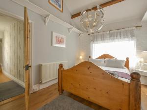 Stokenham2 Bayview的一间卧室配有一张木床和吊灯。