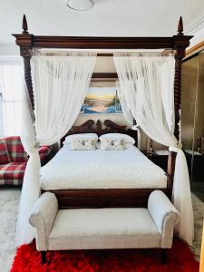 勒威克Norlande的卧室配有带白色窗帘的天蓬床