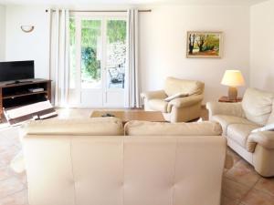 卡雅克Holiday Home La Combelle - CJC400 by Interhome的客厅配有沙发、椅子和电视
