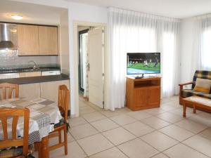 卡拉德费斯特拉特Apartment Tamarindo-1 by Interhome的厨房以及带桌子和电视的客厅。