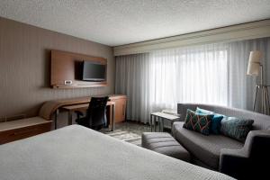 坦培Sonesta Select Tempe Downtown的酒店客房配有一张床、一张书桌和一张沙发。
