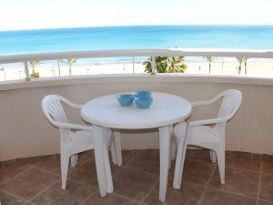 La VentetaApartment Urbaeuropa by Interhome的白色的桌椅,享有海滩美景