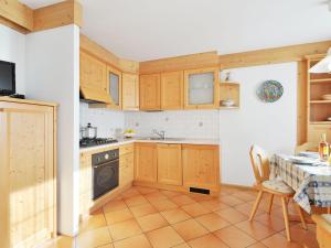 坎皮泰洛Apartment Lazzer-2 by Interhome的厨房配有木制橱柜、桌子和炉灶。