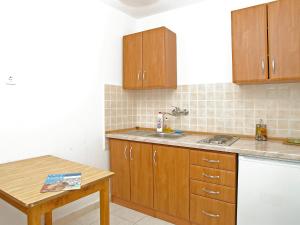 尼亚卢卡Apartment Šarenko-3 by Interhome的厨房配有木制橱柜、水槽和桌子