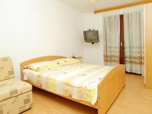 尼亚卢卡Apartment Šarenko-3 by Interhome的卧室配有一张床,墙上配有电视。