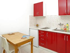 尼亚卢卡Apartment Šarenko-4 by Interhome的厨房配有红色橱柜和木桌