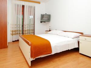 尼亚卢卡Apartment Šarenko-4 by Interhome的一间卧室配有一张床,墙上配有电视