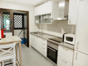 圣费德洛斯博利什Apartment Mirador de la Yesera by Interhome的厨房配有白色橱柜、水槽和微波炉