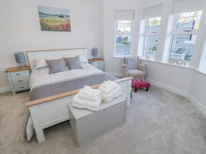 本莱赫Hafan Traeth Beach Haven的一间卧室配有一张床、一把椅子和窗户。