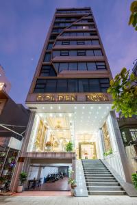 岘港Golden Rose Hotel by THG的前面有楼梯的建筑
