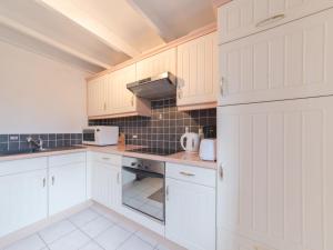 布列登Holiday Home New Village Park-3 by Interhome的厨房配有白色橱柜和炉灶烤箱。