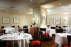 伦敦伦敦桥酒店的餐厅配有桌椅和白色的桌布