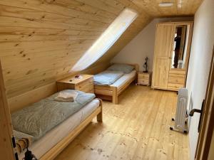 PliešovceChalupa v prírode的配有木天花板的客房内的两张床