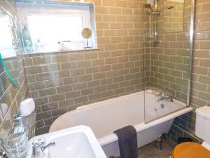马尔文维尔Kitts Cottage的带浴缸、水槽和窗户的浴室