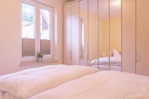 Groß KirrHaus Sabine - EG的卧室配有白色的床和镜子