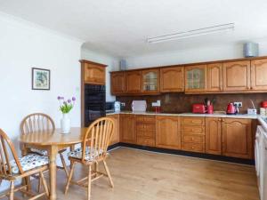霍尔特Skylark的厨房配有木制橱柜和桌椅