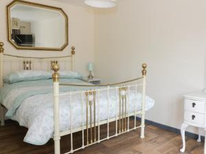 霍舍姆圣斐德Foxley Wood Cottage的卧室配有白色的床和镜子