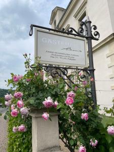 梅森索倪姿酒店的粉红色玫瑰的建筑前的标志