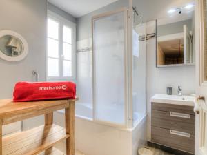 迪纳尔Apartment La Plage-1 by Interhome的带淋浴的浴室和桌子上的红色袋子