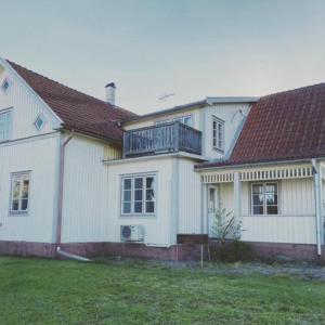 TimmernabbenVilla Löfström的白色的房子,上面设有阳台