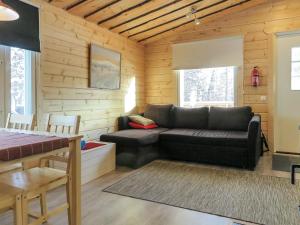 萨利色尔卡Holiday Home Poromies d by Interhome的小木屋内带黑色沙发的客厅