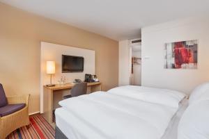 波鸿波鸿H+酒店的酒店客房配有两张床和一张书桌