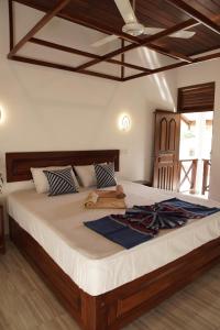 迪克韦勒Surf Nest Hiriketiya的一间卧室配有一张大床和木制床头板