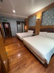 花莲市采盈精品休闲旅馆的配有2张床的酒店客房,铺有木地板
