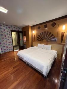 花莲市采盈精品休闲旅馆的铺有木地板的客房内一张大白色的床