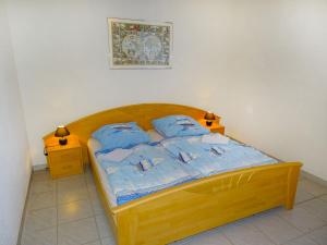 高尔维茨Apartment Gollwitzer Park - Insel Poel-9 by Interhome的一间卧室配有一张带蓝色枕头的木床。