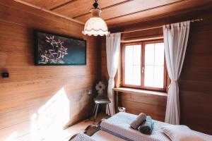 埃尔比格纳尔普Alpenherz Chalet的一间卧室设有木墙和一张带窗户的床