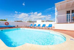 马赫Villa Candela的游泳池周围设有蓝色椅子