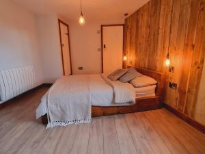 埃克塞特Pass the Keys Charming 19th century country cottage for 2 guests的一间卧室配有一张木墙床