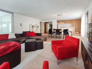 达沃斯Apartment Seewiesenstrasse by Interhome的带沙发和红色椅子的客厅