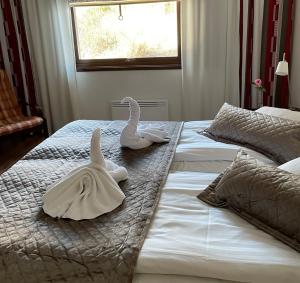 埃克勒伊克罗餐厅酒店的卧室内的两张床上带两条天鹅绒毛巾