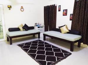 蓬蒂切里Aarudhara Holiday Home (A Home away from Home)的客厅配有两张沙发和地毯。