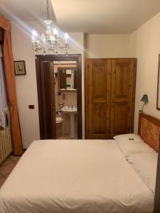 法纳诺佛罗伦萨酒店的一间带白色大床的卧室和一间浴室