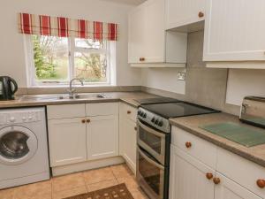 巴尔伯恩Fleshbeck Cottage的厨房配有白色橱柜和洗碗机。