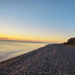 Marina di GairoNew Camping Coccorrocci的海滩上一片岩石,阳光照耀着大海