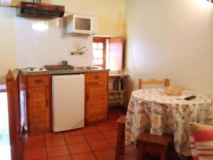 萨布盖鲁克鲁塞罗之家农家乐的厨房配有桌子和白色冰箱。
