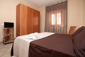 巴格里亚迪拉祖迪欧利安德雷2号公寓的一间卧室设有一张大床和一个窗户。
