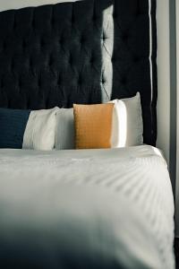 哈德斯菲尔德Dealhouse Apartments 10的一张带枕头的黑色床头板床