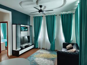 哥打巴鲁LUXURY Modern House Kubang Kerian UNIFI 4 Bedrooms的客厅配有蓝色窗帘、沙发和电视