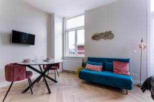 莱岑丹Novallure Short Stay Apartments的客厅配有蓝色的沙发和桌子