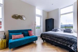 莱岑丹Novallure Short Stay Apartments的一间卧室配有一张床和一张蓝色的沙发