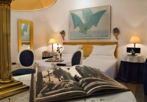 罗马罗坎达凯洛利酒店的一间卧室设有两张床,一张桌子上写着一本书