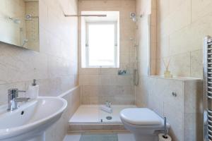 伦敦Homely 2 Bedroom Victorian Apartment in Hampstead的浴室配有盥洗盆、卫生间和浴缸。