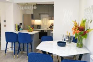 利特尔Outstanding modernised 3/4 double bedroomed house的厨房配有白色的桌子和蓝色的椅子